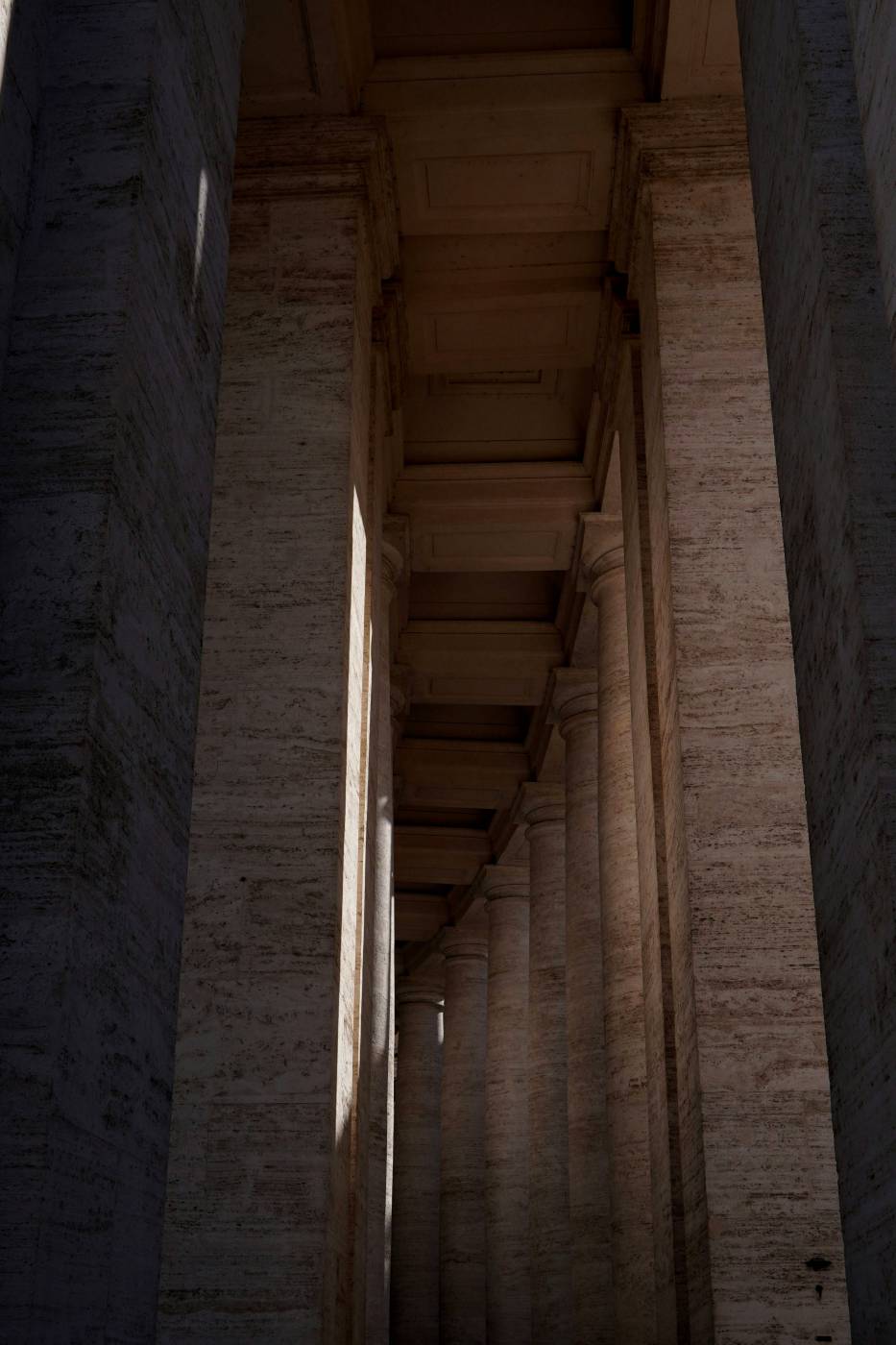 column a long hallway with columns and a clock on the wall grey picture